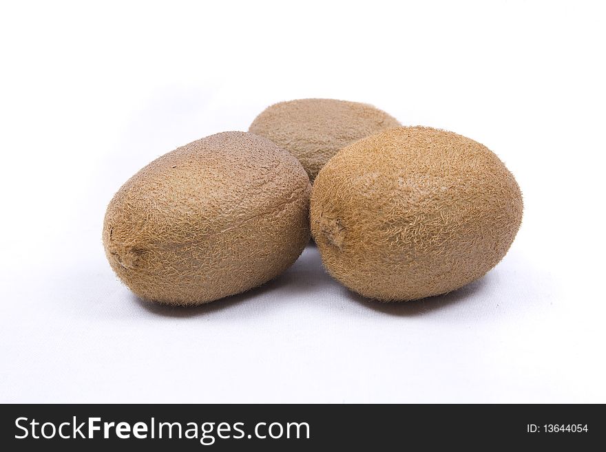 Thee kiwi fruit sit isolated on a white background. Thee kiwi fruit sit isolated on a white background