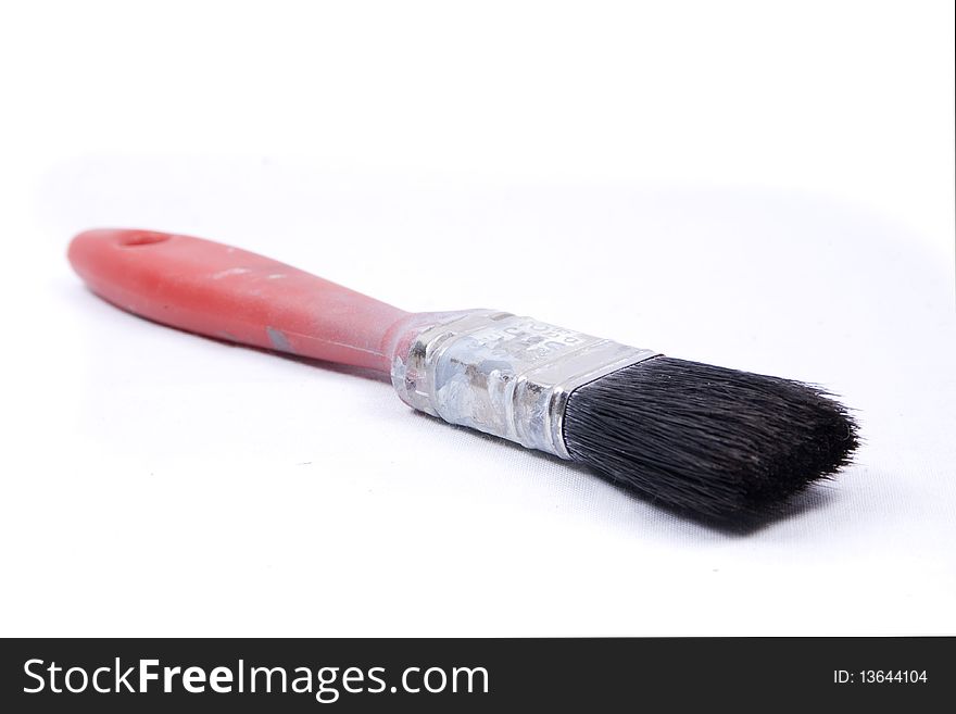 An old, worn decorators paint brush isolated on a white background. An old, worn decorators paint brush isolated on a white background