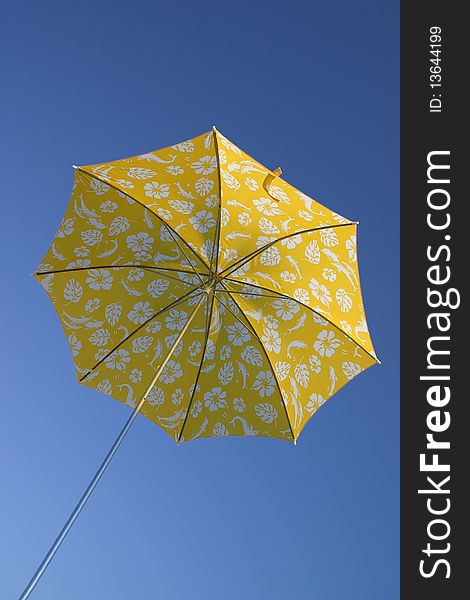 Yellow umbrella in blue sky low angle view