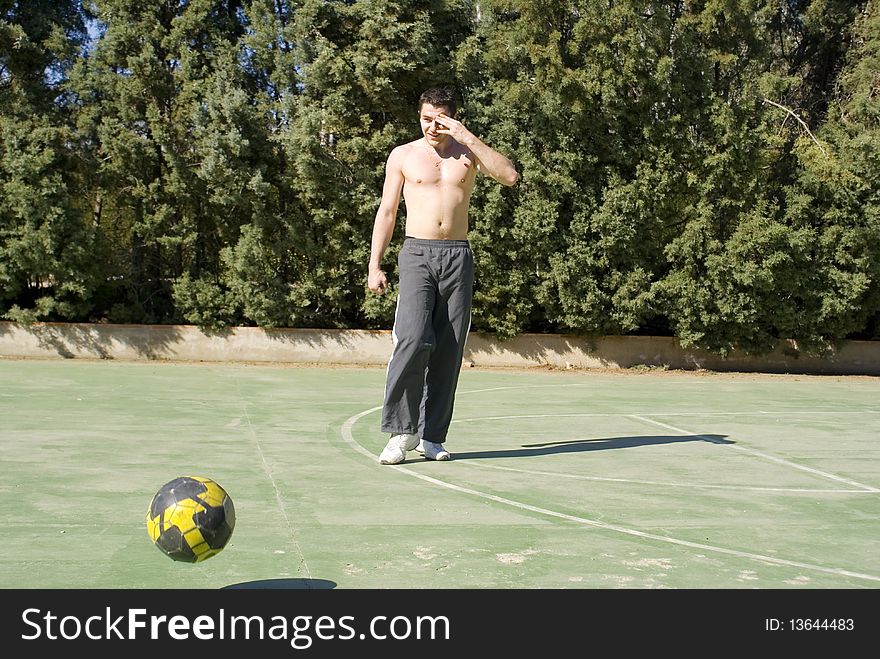 A young man playing football on a sunny warm day. A young man playing football on a sunny warm day