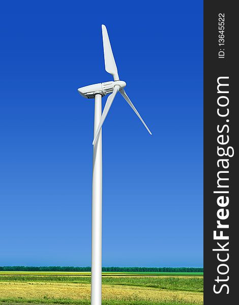 Beautiful green meadow with wind turbine generating electricity