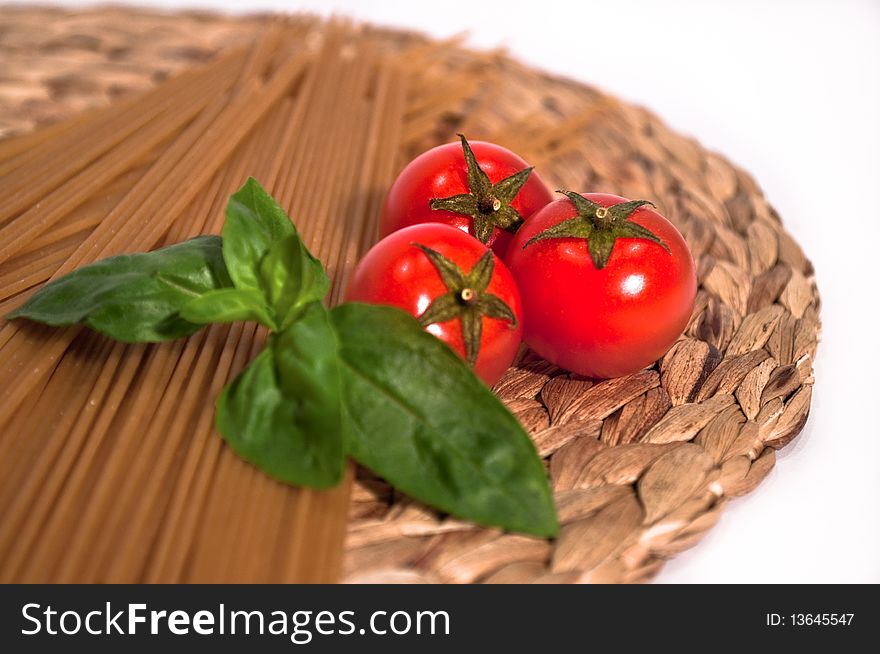 Whole wheat spaghetti with three perfect cherry tomatoes and basil. Whole wheat spaghetti with three perfect cherry tomatoes and basil