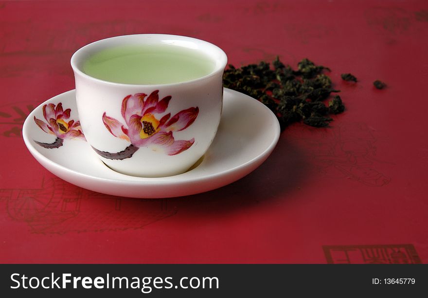 Green tea in a cup on a red background