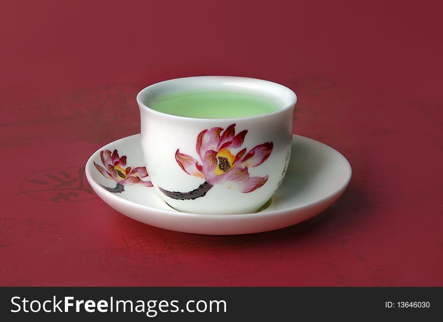 Green tea in a cup on a red background