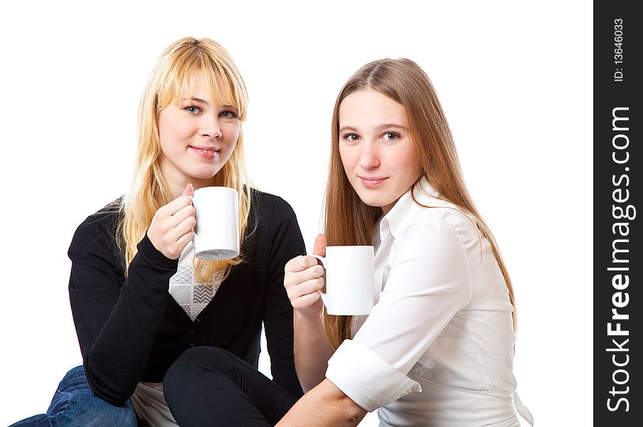 Two teenage girls is drinking tea. Isolated on white background