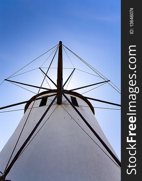 A close up look at a windmill. Looking directly up at it with blue skies behind it. A close up look at a windmill. Looking directly up at it with blue skies behind it.