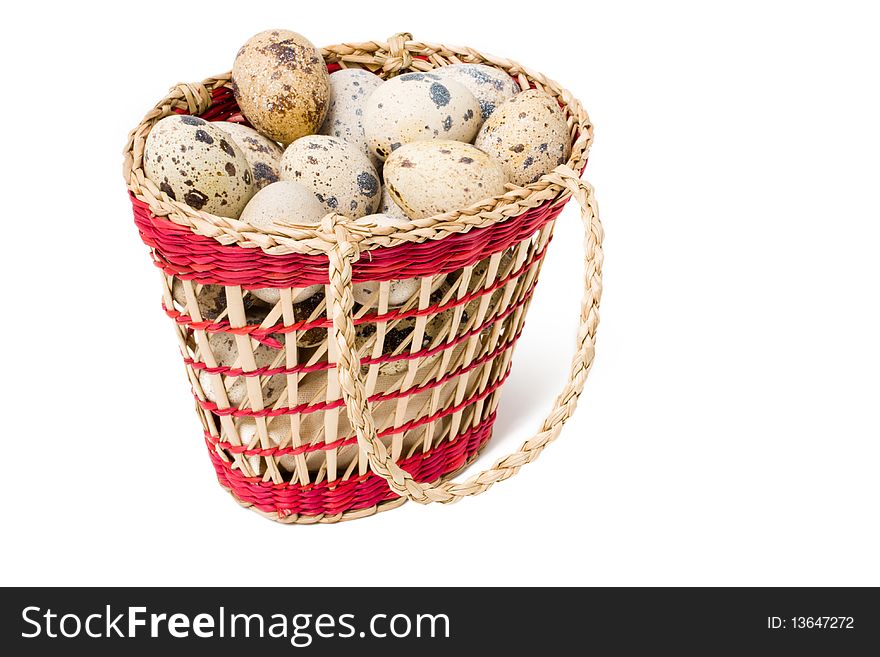 Quail eggs in a straw basket on a white background