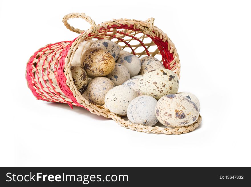 Quail eggs in a straw basket on a white background