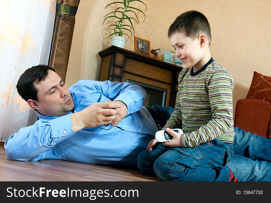 Happy family home: father and son playing on the floor. Happy family home: father and son playing on the floor