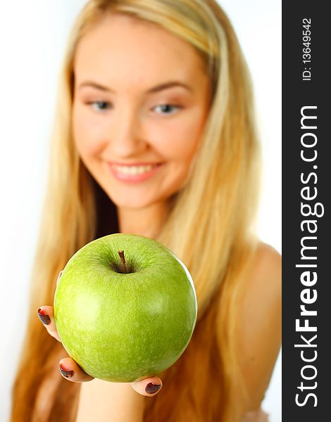 Young woman holding an apple into the camera - focus on apple. Young woman holding an apple into the camera - focus on apple