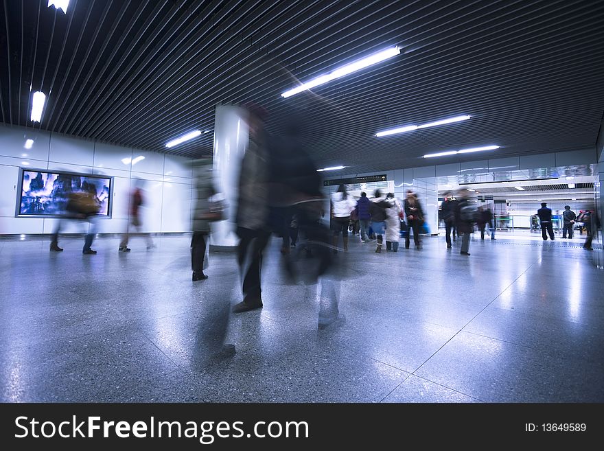 Clean tiled floor, reflection of light on floor and blurred view of people walking. Clean tiled floor, reflection of light on floor and blurred view of people walking