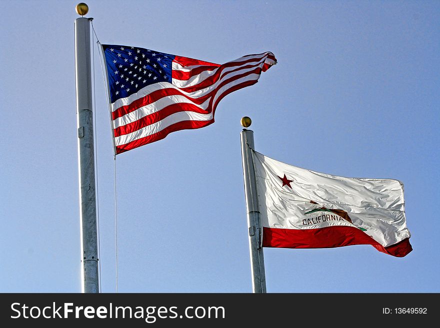 The Stars and Stripes and the California bear fags, are seen blowing in a strong wind. The Stars and Stripes and the California bear fags, are seen blowing in a strong wind.