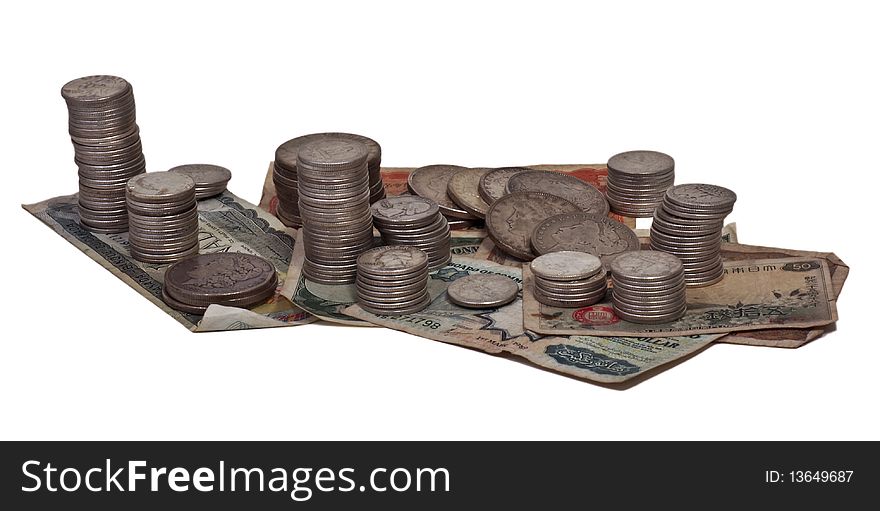 Silver coins and assorted currency on white background. Silver coins and assorted currency on white background