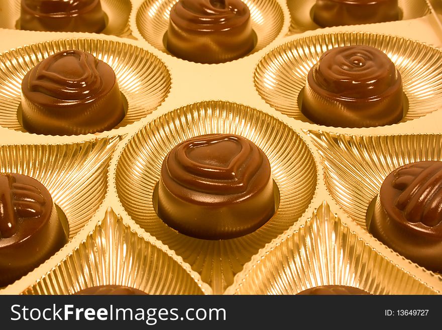 Candy with heart shape on golden plates. Candy with heart shape on golden plates