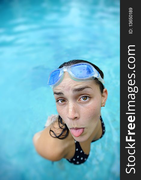 Pretty girl sticks tongue out at the pool. Pretty girl sticks tongue out at the pool