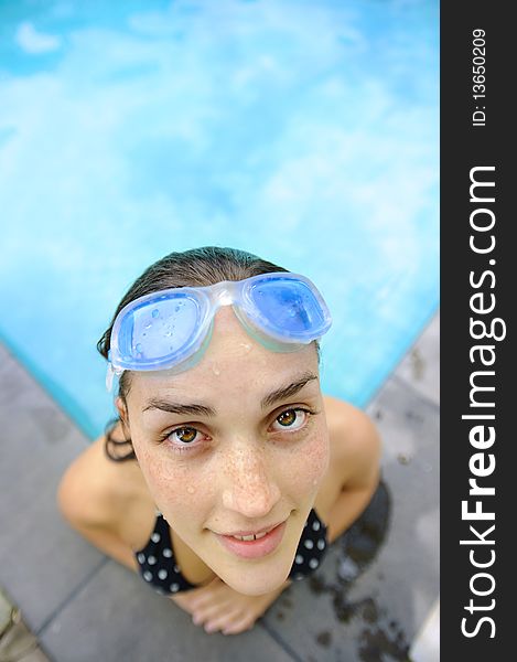 Girl looks up toward camera while in the pool. Girl looks up toward camera while in the pool