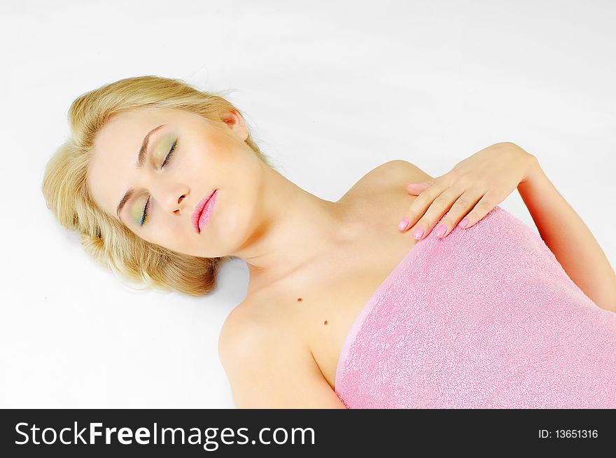 Lying young beauty woman  in a pink bath towel with a bit soft effect. Lying young beauty woman  in a pink bath towel with a bit soft effect