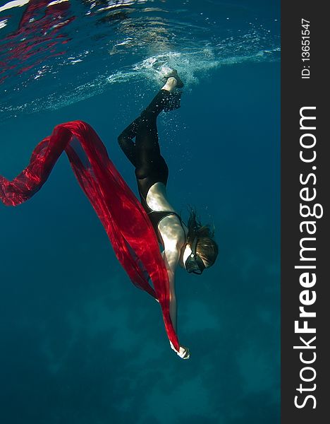 Young girl with a red cloth under the water plays the fool. Young girl with a red cloth under the water plays the fool