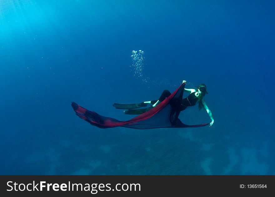 Young girl with a red cloth under the water plays the fool. Young girl with a red cloth under the water plays the fool