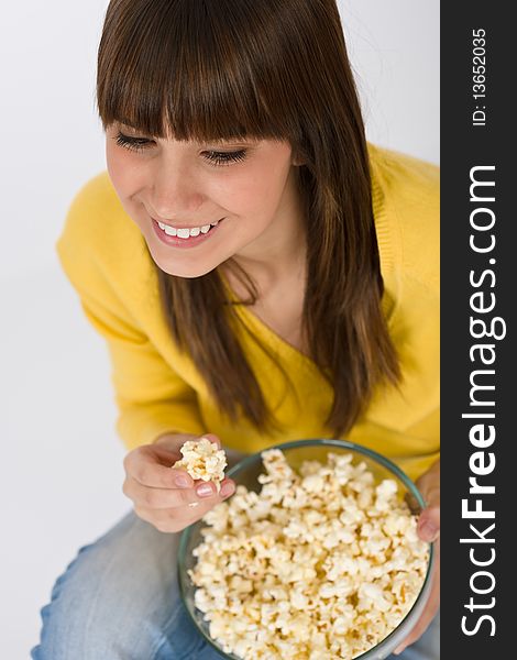 Smiling female teenager holding bowl with popcorn. Smiling female teenager holding bowl with popcorn