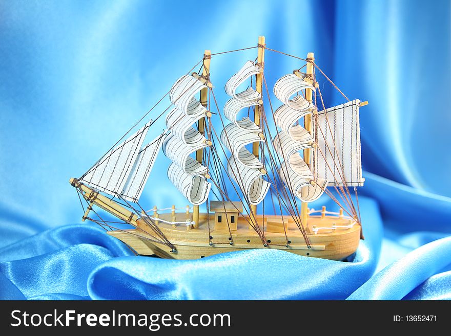 Model of a sailing yacht on a blue background. Model of a sailing yacht on a blue background
