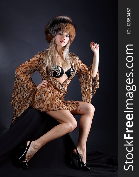 Fashion young woman in dress with leopard style anf fur winter hat