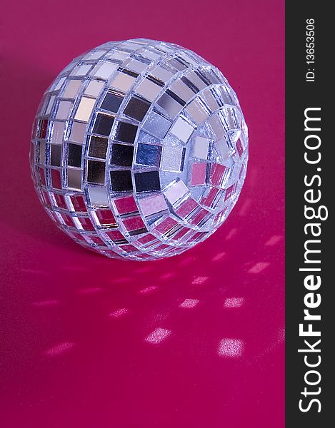 Music disco ball on pink background, light reflections