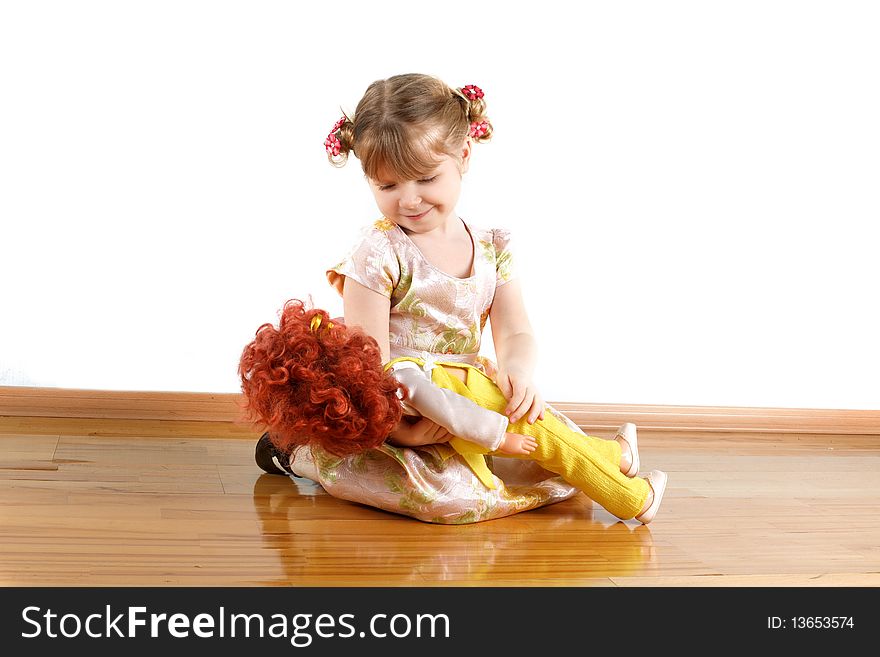 Little girl with doll at wall in room