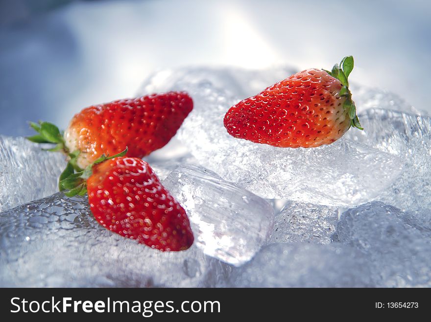 Pretty raw red strawberries lying on large pieces of ice. Pretty raw red strawberries lying on large pieces of ice