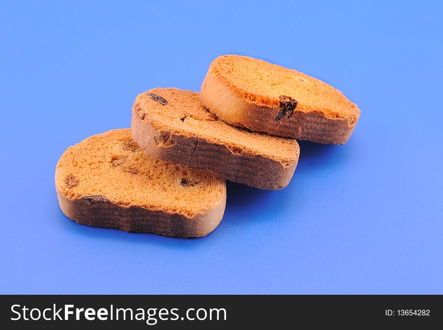 Three crackers with raisins lie in front of blue background. Three crackers with raisins lie in front of blue background
