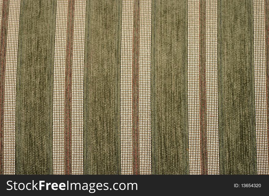 A closeup of green and gold striped upholstery fabric. A closeup of green and gold striped upholstery fabric.