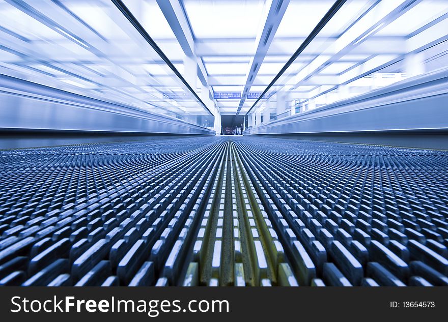 Close-up of moving escalator in blue corrior. Close-up of moving escalator in blue corrior