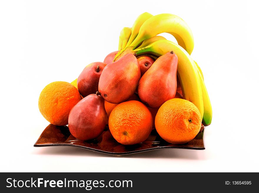 Fruit, pears, oranges and bananas on a plate photographed in front of white background. Fruit, pears, oranges and bananas on a plate photographed in front of white background
