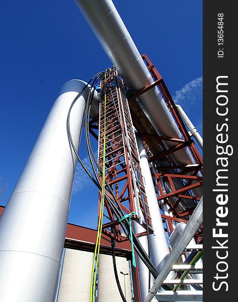 Industrial pipelines on pipe-bridge against blue sky. Industrial pipelines on pipe-bridge against blue sky