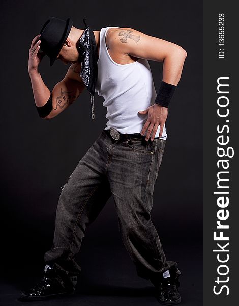 Young stylish asian dancer in front of black background moving to hip jop music. Young stylish asian dancer in front of black background moving to hip jop music.