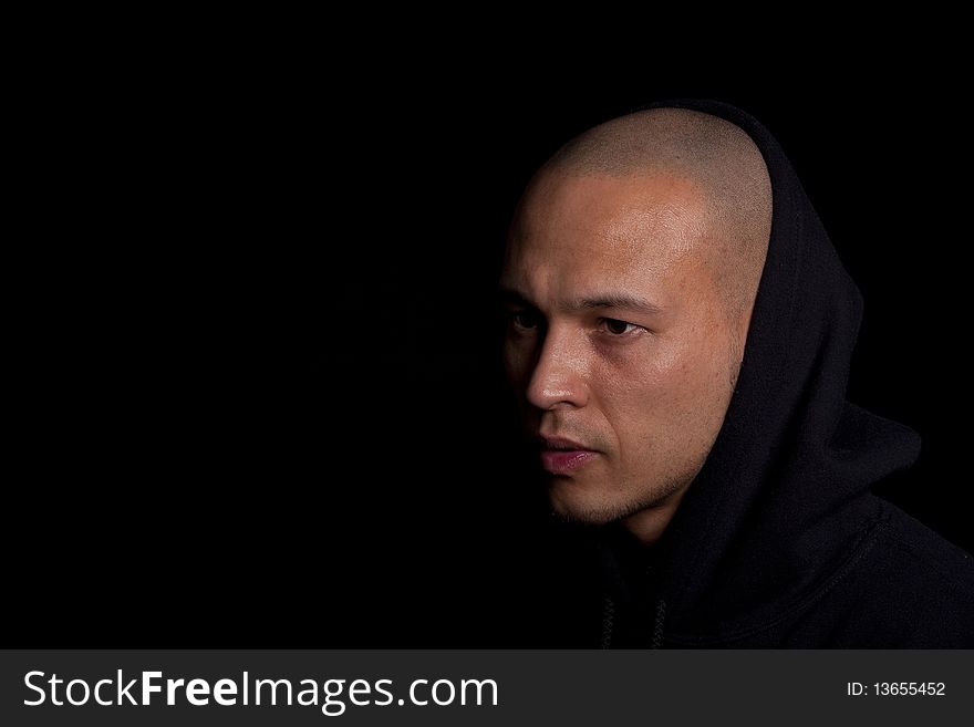 Stylish young man with hoddie over a black background.