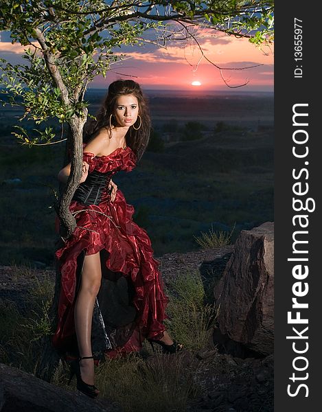 Nice female model in red against the coming sun. Nice female model in red against the coming sun.