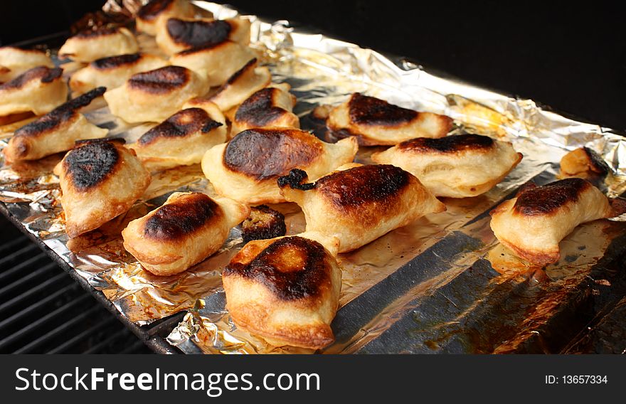 Detailed image of perogies cooking on top rack of BBQ. Detailed image of perogies cooking on top rack of BBQ.