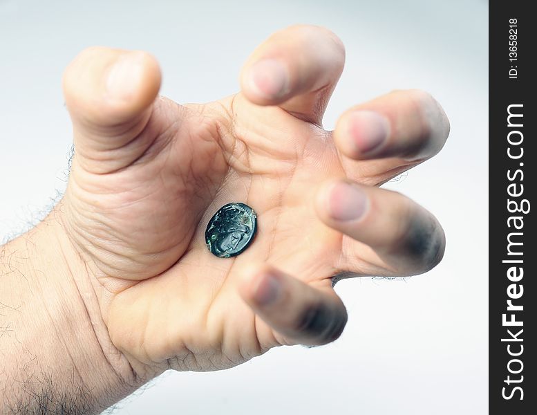 Old roman coin in threaten human hand