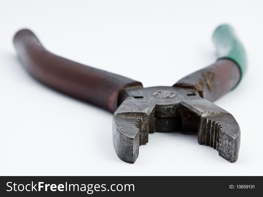 Old green and brown combination pliers on white underground