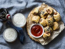 Served Appetizers Table - Minced Puff Pastry Rolls And Beer On Grey Background, Top View. Flat Lay. Stock Images Served Appetizers Table - Minced Puff Pastry Rolls And Beer On Grey Background, Top View. Flat Lay. Stock Images