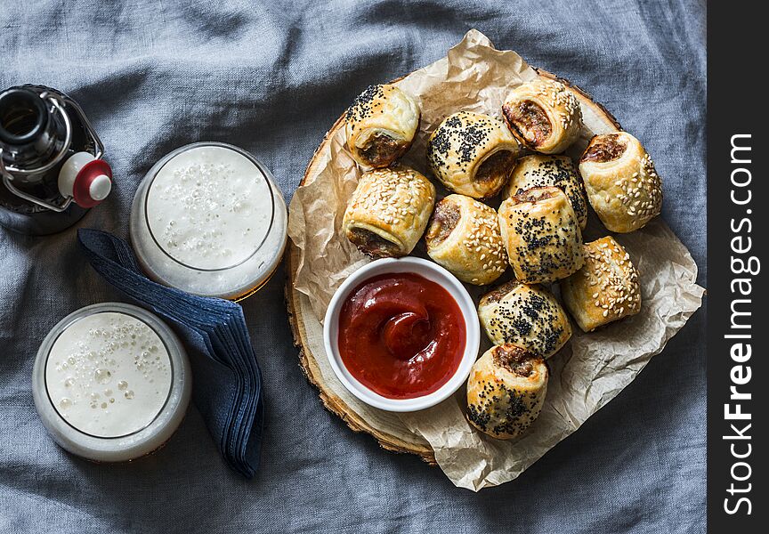 Served Appetizers Table - Minced Puff Pastry Rolls And Beer On Grey Background, Top View. Flat Lay.