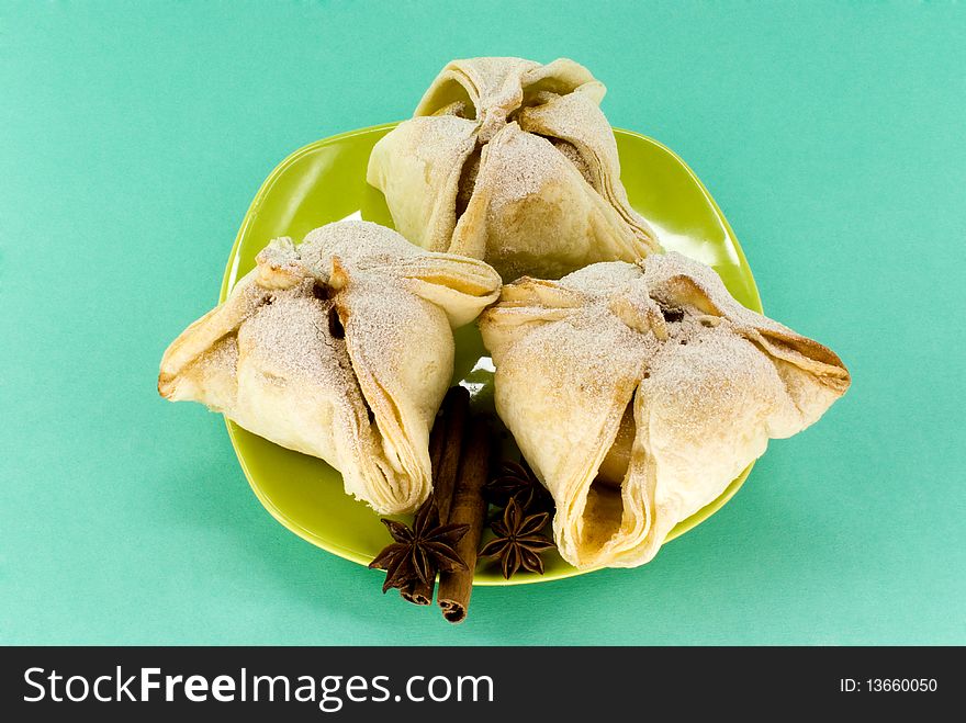 Small cakes on plate against green background