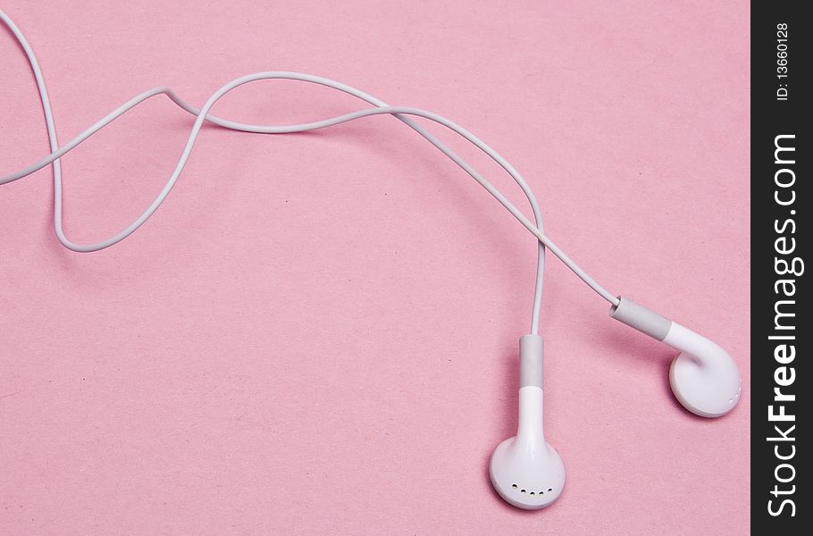 White headphones on a pink background. White headphones on a pink background.