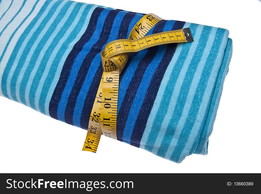 Beach towel with measuring tape. Summertime is when people go on diets so they can look good in baiting suits at the beach! Isolated on white with a clipping path. Beach towel with measuring tape. Summertime is when people go on diets so they can look good in baiting suits at the beach! Isolated on white with a clipping path.