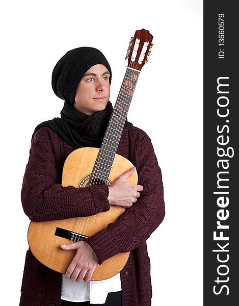 Teenager with a knitted cap and scarf holding a guitar. Teenager with a knitted cap and scarf holding a guitar.