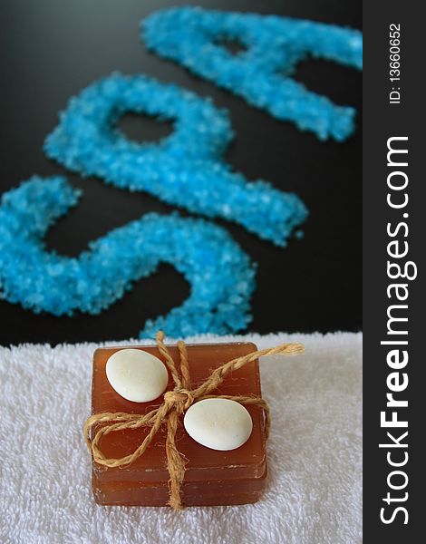 Spa concept. Sea salt and soap on dark background.