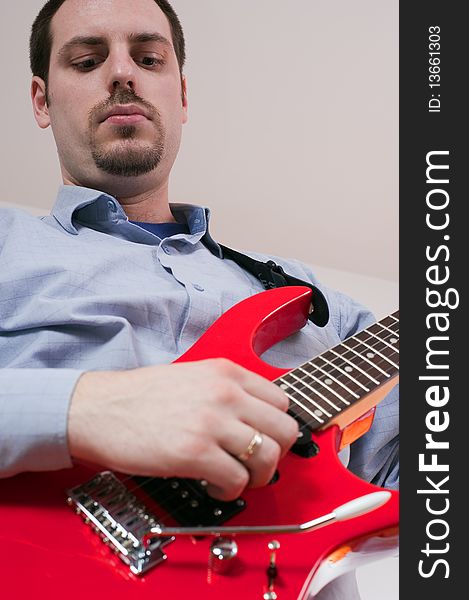 Young man, playing a red electric guitar. Young man, playing a red electric guitar