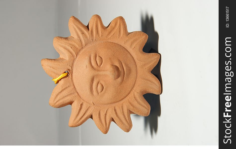 A small clay smiling sun.