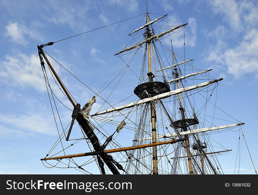 Landscape view of tall ship rigging against blue cloudy sky